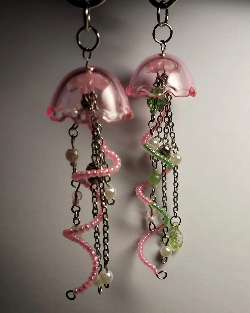 A pair of pink glass jellyfish keychains with beaded tendrils