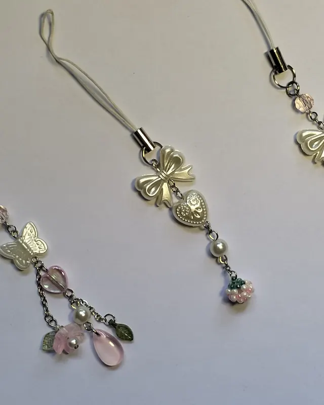 Phone charms with pearl bows, butterflies and pink glass drops on cord straps
